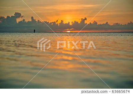 sunset and siluet of fisherman very far away sunset and siluet of fisherman very far away 63665674
