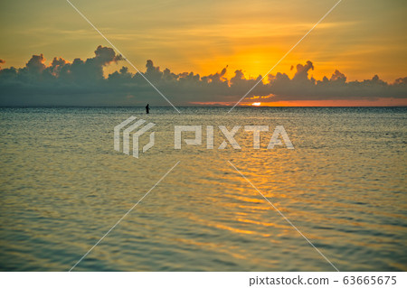 sunset and siluet of fisherman very far away sunset and siluet of fisherman very far away 63665675