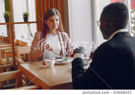 Internationals people sitting in a cafe and drinking a coffee Internationals people sitting in a cafe and drinking a coffee 63666041
