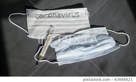 Coronavirus. Medical disposable gauze bandages are on the table. A mercury glass thermometer Coronavirus. Medical disposable gauze bandages are on the table. A mercury glass thermometer 63666621