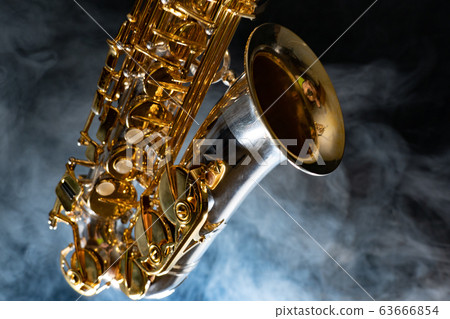 Golden shiny alto saxophone on black background with smoke. copy space 63666854