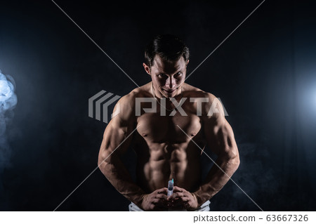 Bodybuilder holding big syringe with injection. concept of steroid in the sport and addiction Bodybuilder holding big syringe with injection. concept of steroid in the sport and addiction 63667326