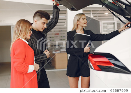 Stylish and elegant people in a car salon Stylish and elegant people in a car salon 63667999