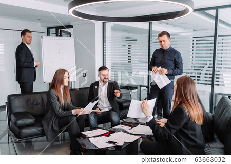 Male and female professionals having discussion at table in new office 63668032