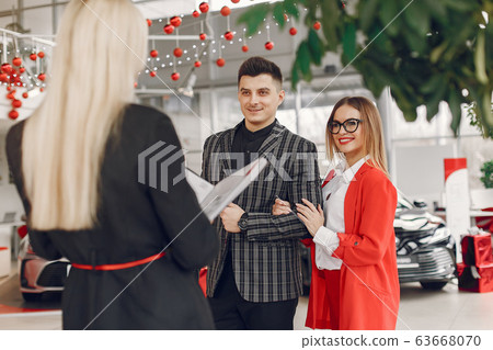 Stylish and elegant people in a car salon 63668070