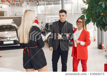 Stylish and elegant people in a car salon 63668073