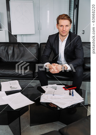 handsome businessman sitting on sofa in modern office handsome businessman sitting on sofa in modern office 63668220