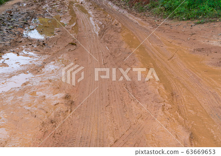 Mud and puddles on the dirt road in countryside Mud and puddles on the dirt road in countryside 63669653
