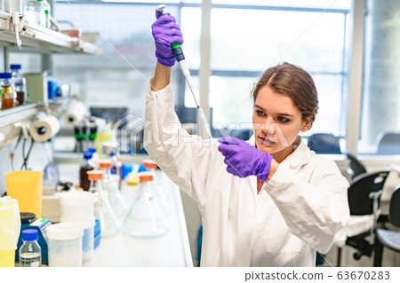 hand of girl drips from pipette onto glass slide hand of girl drips from pipette onto glass slide 63670283