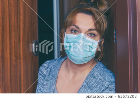 Woman wearing a protective face mask opening a 63672208