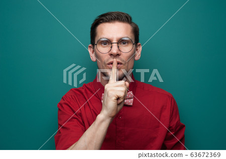 Handsome young man in a red shirt and bow-tie 63672369