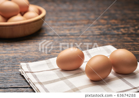 Organic chicken eggs in a wooden bowl on a kitchen Organic chicken eggs in a wooden bowl on a kitchen 63674288