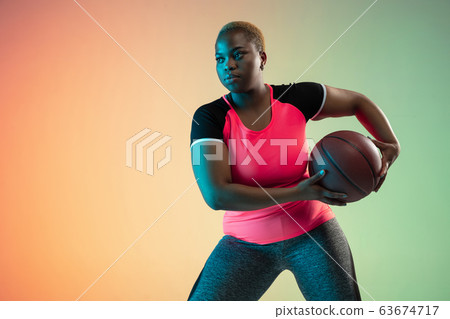 Young african-american plus size female model's training on gradient background Young african-american plus size female model's training on gradient background 63674717
