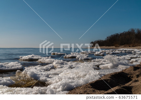 Russia. Saint-Petersburg. Remnants of ice and a view of the Gulf of Finland in early spring from the southern shore of Kronstadt. Russia. Saint-Petersburg. Remnants of ice and a view of the Gulf of Finland in early spring from the southern shore of Kronstadt. 63675571