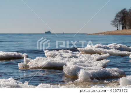 Russia. Saint-Petersburg. Remnants of ice and a view of the Gulf of Finland in early spring from the southern shore of Kronstadt. 63675572