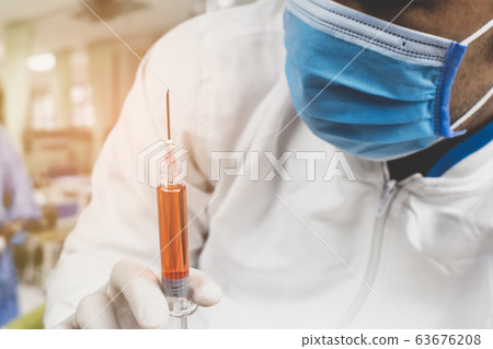 Medical vaccine syringe for medicine injection treatment holding in a hand of the doctor. Medical vaccine syringe for medicine injection treatment holding in a hand of the doctor. 63676208