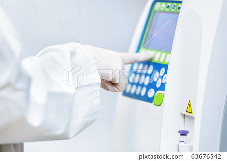 Close up view of laboratory equipment. Blood contaminated by Coronavirus and a sample of it being Close up view of laboratory equipment. Blood contaminated by Coronavirus and a sample of it being 63676542