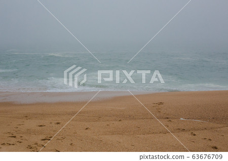 Sea and sandy beach in dense fog, autumn day 63676709