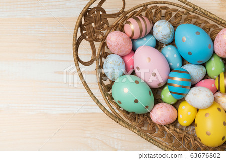 Basket with colorful Easter eggs on wooden 63676802