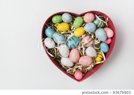 Colorful Easter eggs in heart shaped box on white 63676803
