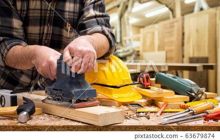 Carpenter at work on wooden boards. Carpentry. 63679874
