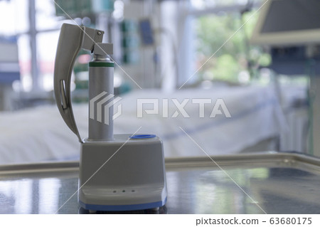 Laryngoscope for tracheal intubation on charge station in ICU in hospital. Intubation of covid patients is very risky for medical staff. Laryngoscope for tracheal intubation on charge station in ICU in hospital. Intubation of covid patients is very risky for medical staff. 63680175