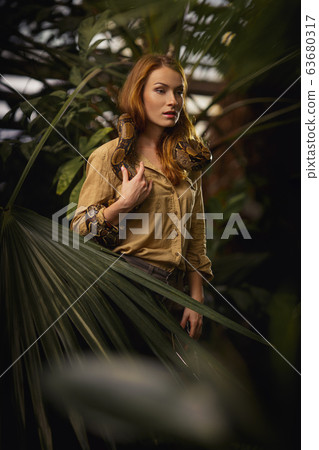 Beautiful girl with a python on the shoulders 63680317