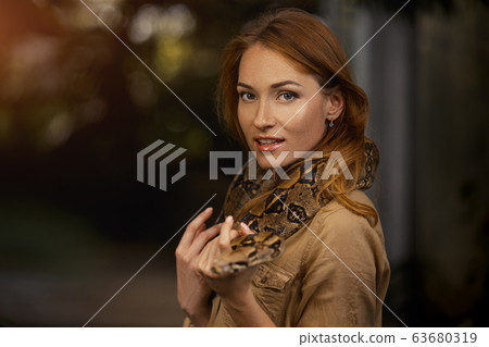 Beautiful girl with a python on the shoulders Beautiful girl with a python on the shoulders 63680319