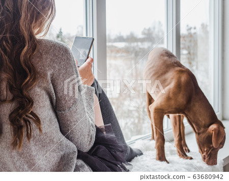 Stylish woman and pretty puppy. Close up 63680942