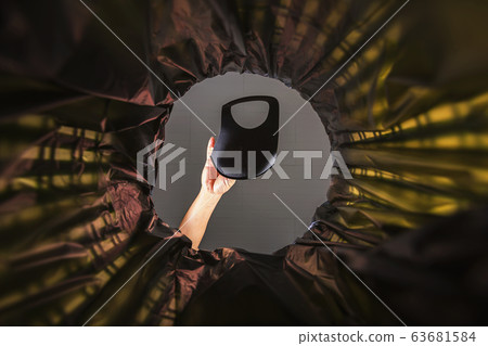 Throwing a face mask into the trash. 63681584