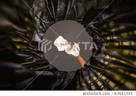 White cloth thrown into the garbage bag. 63681585