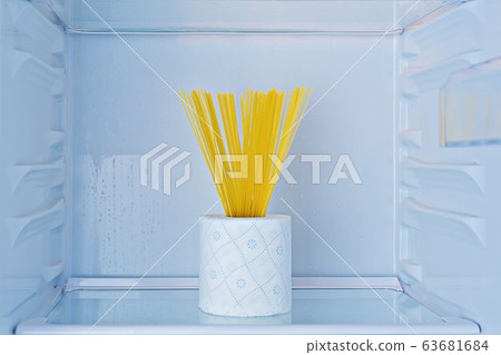 Rolls of toilet paper and pasta on shelf in fridge Rolls of toilet paper and pasta on shelf in fridge 63681684