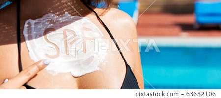 Young girl showing on spf inscription on her Young girl showing on spf inscription on her 63682106