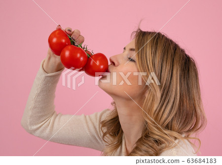 Modern woman kissing ripe tomatoes 63684183
