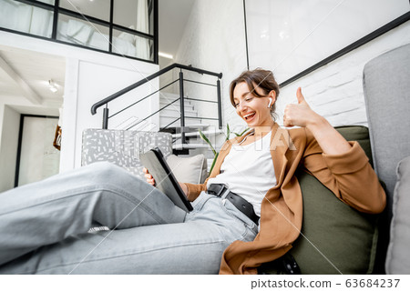 Portrait of a woman working on a tablet at home 63684237