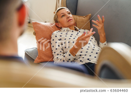 Depressed female patient lying on a sofa Depressed female patient lying on a sofa 63684460
