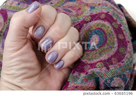 Hand of an adult woman with painted nails, 63685196