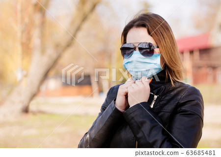 woman in a protective mask and sunglasses 63685481