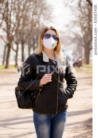 Young woman in a mask is walking 63685486