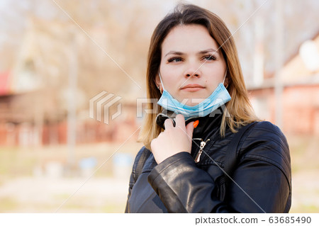 woman breathes fresh air in a mask on her face. 63685490