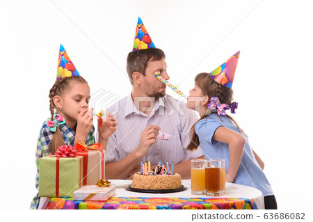 Girl got into the eyes of dad blowing a festive 63686082