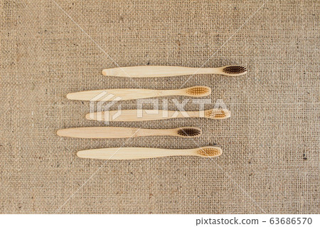 Set of natural bamboo toothbrushes on rustic burlap background Set of natural bamboo toothbrushes on rustic burlap background 63686570