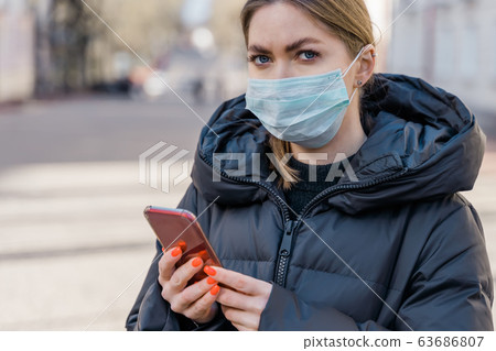 Pportrait of woman in protective medical mask using smart phone on empty european streets. Health and safety, N1H1 coronavirus, covid-19, virus protection care and medical concept. Pan left shot. Pportrait of woman in protective medical mask using smart phone on empty european streets. Health and safety, N1H1 coronavirus, covid-19, virus protection care and medical concept. Pan left shot. 63686807