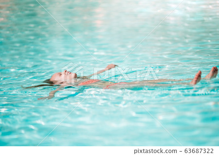 Adorable little girl swimming at outdoor swimming pool Adorable little girl swimming at outdoor swimming pool 63687322