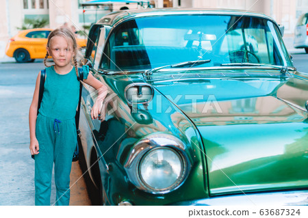 Tourist girl in popular area in Havana, Cuba. Young kid traveler smiling Tourist girl in popular area in Havana, Cuba. Young kid traveler smiling 63687324