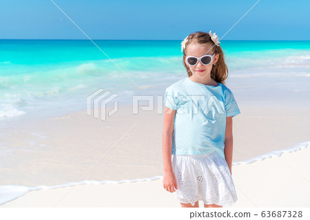 Adorable little girl have fun at tropical beach during vacation Adorable little girl have fun at tropical beach during vacation 63687328