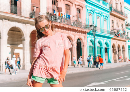 Tourist girl in popular area in Havana, Cuba. Young kid traveler smiling Tourist girl in popular area in Havana, Cuba. Young kid traveler smiling 63687332