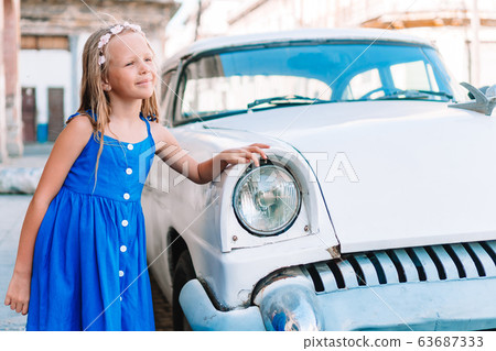 Tourist girl in popular area in Havana, Cuba. Young kid traveler smiling Tourist girl in popular area in Havana, Cuba. Young kid traveler smiling 63687333