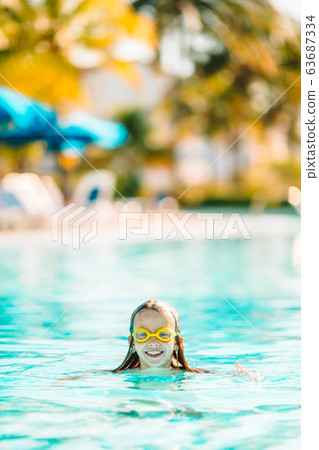 Adorable little girl swimming at outdoor swimming pool Adorable little girl swimming at outdoor swimming pool 63687334