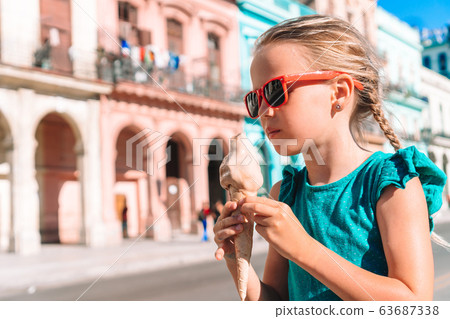 Adorable little girl eating ice-cream in popular area in Old Havana, Cuba. 63687338